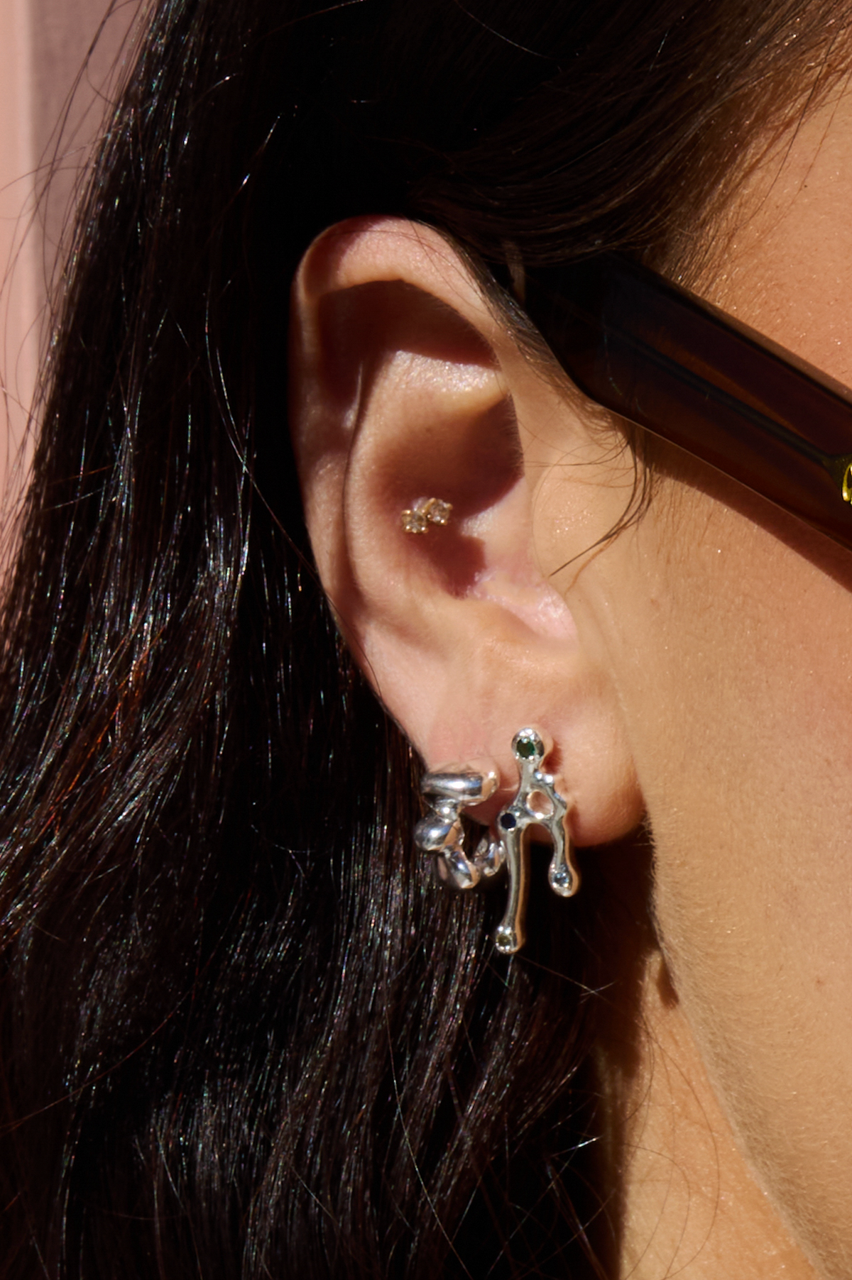 Lucius silver-tone sculptural stud earrings worn on the ear